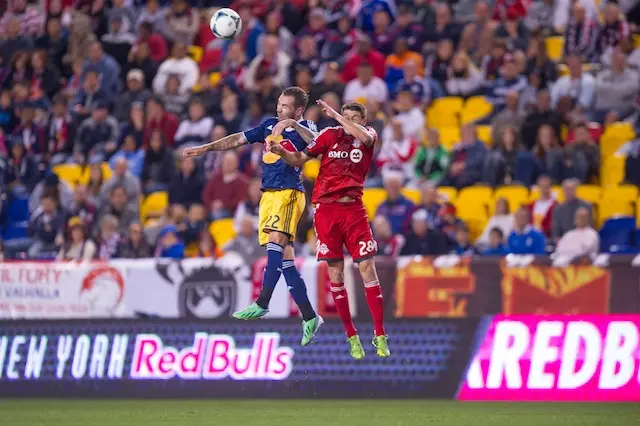 Jonny Steele challenges for a header with Toronto's Mark Bloom.